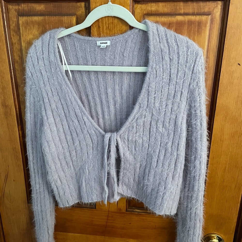 A long sleeve sweater, a little cropped, is furry